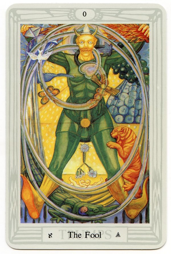 The Fool, Thoth Tarot. A green, horned figure of spring strides through the air with arms flung wide, a tiger at his leg and a crocodile below. Around him swirl the emblems of unborn possibility: a vulture and a dove, grapes and a butterfly, twin infants in embrace, coins and a caduceus, and the winged egg wrapped by a serpent. He is Dionysus, the Green Man, the holy fool and Harpocrates, the child of silence, at once.